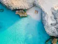 Para idealnie wypoczywa na plaży, marząc o kolejnych aruba wakacjach. Turkusowa woda i biały piasek tworzą rajski krajobraz.