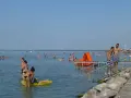 Tłum ludzi cieszy się kąpielą w Balatonie. Idealna temperatura wody zachęca do zabawy na dmuchanych zabawkach i zjeżdżalniach.