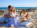 Romantyczny piknik na plaży na Cyprze. Para cieszy się chwilą, a na stole czekają przysmaki. Idealne na wycieczki fakultatywne.