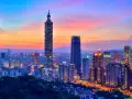 Wieczorny widok na Taipei 101 i inne drapacze chmur, stolica Tajwanu, rozświetlone w blasku zachodzącego słońca.