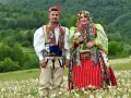 Para w tradycyjnych strojach na tle zielonych wzgórz. Ciekawe albania ciekawostki o kulturze i tradycji.