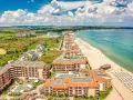 Widok z lotu ptaka na kurort nad Morzem Czarnym. Kompleksy hotelowe z basenami i plażą z leżakami. Czy w Bułgarii jest drogo?