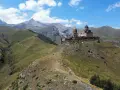 Gruzja wakacje: Kościół Gergeti na tle gór Kaukazu. Widok na malownicze doliny i szczyt Kazbek.