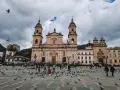 Plac w stolicy Kolumbii, z dominującą katedrą i tłumem ludzi wśród gołębi.