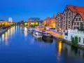 Bydgoszcz: rzeka Brda, łodzie, zabytkowe kamienice i rzeźba na linie. Nietypowe atrakcje Bydgoszcz zachwycają o zmierzchu.