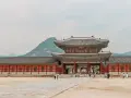 Zwiedzający pałac w Seulu, podziwiający architekturę. Czy Korea Południowa jest bezpieczna? Tak, to kraj przyjazny turystom.