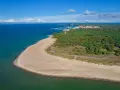 Spokojna plaża i las na Helu poza sezonem. Widać port i miasteczko.