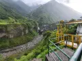 Widok na wodospad i kanion w Vilcabamba. Żółta platforma widokowa z metalową balustradą.