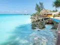 Turkusowe morze i tropikalna zabudowa na skale. Idealne miejsce na relaks, a zanzibar ceny mogą być zaskakująco przystępne.
