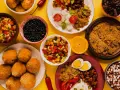Kolorowe brazylijskie jedzenie: ryż, fasola, smażone kulki, sałatka z warzyw i pomarańcza.