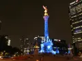 Nocny widok na meksyk miasto, z oświetloną Kolumną Niepodległości i nowoczesnymi wieżowcami w tle.