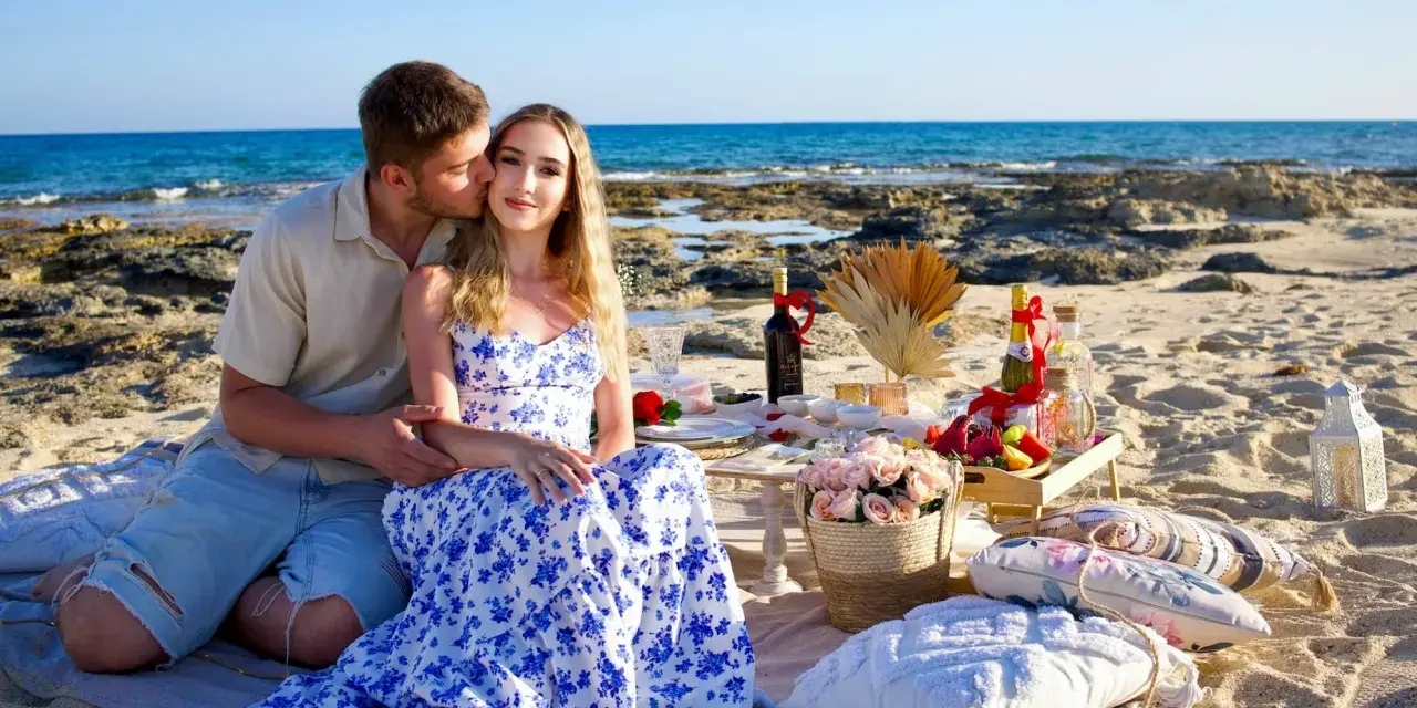 Romantyczny piknik na plaży na Cyprze. Para cieszy się chwilą, a na stole czekają przysmaki. Idealne na wycieczki fakultatywne.