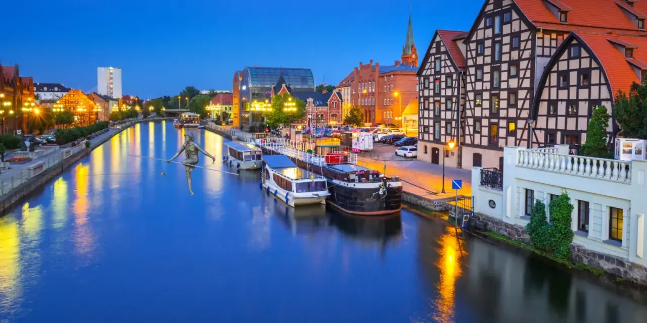 Bydgoszcz: rzeka Brda, łodzie, zabytkowe kamienice i rzeźba na linie. Nietypowe atrakcje Bydgoszcz zachwycają o zmierzchu.