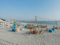 Plaża w Dubaju w lipcu: leżaki, stoliki i girlandy świateł tworzą letnią atmosferę.