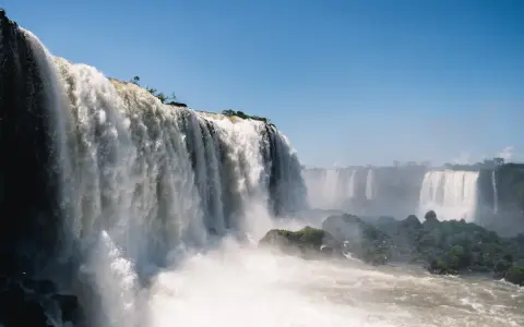 Potężne wodospady Iguazú w Argentynie, kaskady wody spadające z klifów, otoczone zielenią i spowite mgiełką.