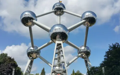 Atomium, symbol Brukseli, lśni w słońcu. To miejsce, gdzie jest Bruksela, przyciąga turystów.