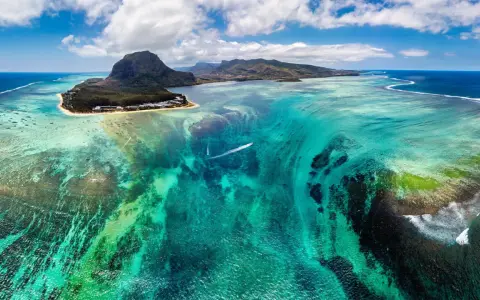 Widok z lotu ptaka na turkusowe wody i góry Mauritiusa. Marzysz o podróży? Mauritius wiza to pierwszy krok do raju.