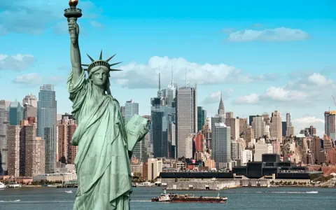 Statua Wolności wita na wycieczce do USA. W tle panorama Nowego Jorku z drapaczami chmur.