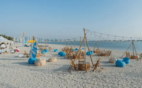 Plaża w Dubaju w lipcu: leżaki, stoliki i girlandy świateł tworzą letnią atmosferę.