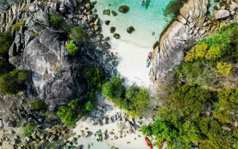 Wybierasz się do Tajlandii? Spakuj kajak i odkrywaj rajskie plaże z krystalicznie czystą wodą, jak ci ludzie na zdjęciu.