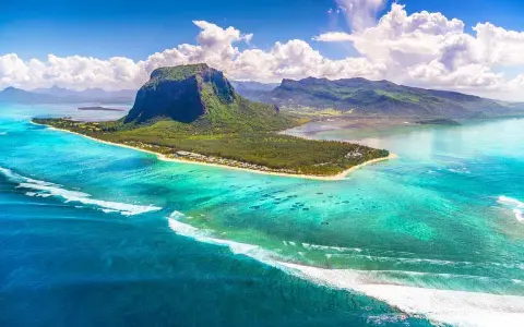 Mauritius pogoda październik: turkusowa woda, zielona góra Le Morne Brabant i białe chmury. Idealna pogoda na rajskie wakacje.
