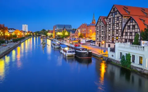 Bydgoszcz: rzeka Brda, łodzie, zabytkowe kamienice i rzeźba na linie. Nietypowe atrakcje Bydgoszcz zachwycają o zmierzchu.