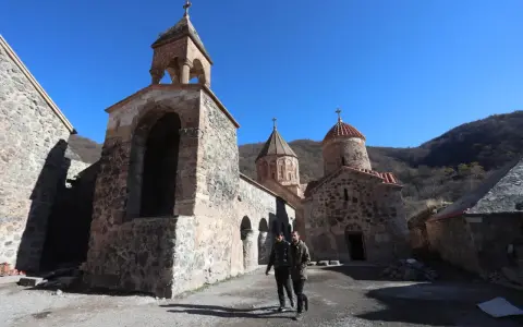Kamienny klasztor w Armenii, świadectwo bogatej historii i religii. Dwóch mężczyzn spaceruje po dziedzińcu.