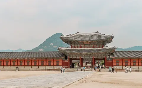 Zwiedzający pałac w Seulu, podziwiający architekturę. Czy Korea Południowa jest bezpieczna? Tak, to kraj przyjazny turystom.