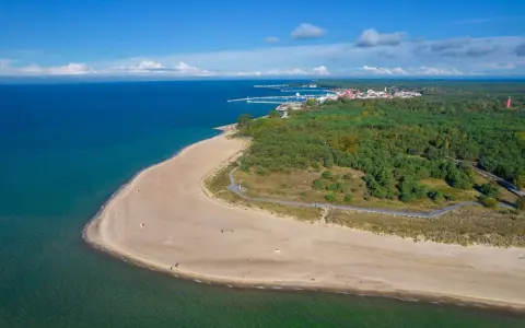 Spokojna plaża i las na Helu poza sezonem. Widać port i miasteczko.