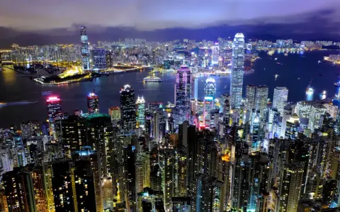 Nocny widok na rozświetlone drapacze chmur w Hongkongu. Czy to miasto, czy państwo, jego blask jest hipnotyzujący.