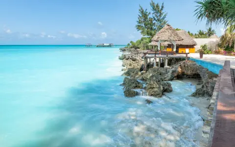 Turkusowe morze i tropikalna zabudowa na skale. Idealne miejsce na relaks, a zanzibar ceny mogą być zaskakująco przystępne.