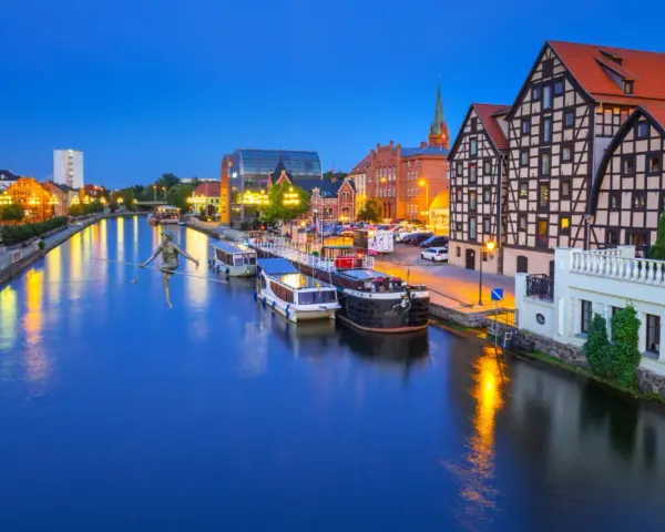 Bydgoszcz: rzeka Brda, łodzie, zabytkowe kamienice i rzeźba na linie. Nietypowe atrakcje Bydgoszcz zachwycają o zmierzchu.