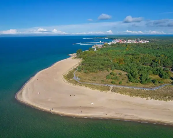 Spokojna plaża i las na Helu poza sezonem. Widać port i miasteczko.