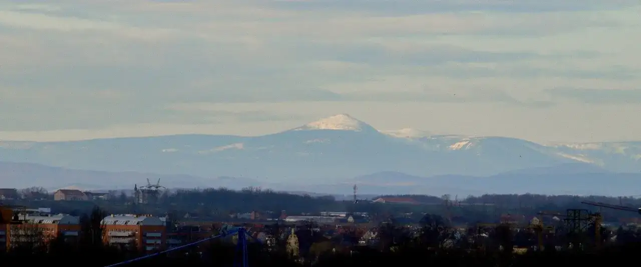 Widok z Wrocławia na ośnieżone góry. W oddali majaczy szczyt, zachęcając do wyprawy.