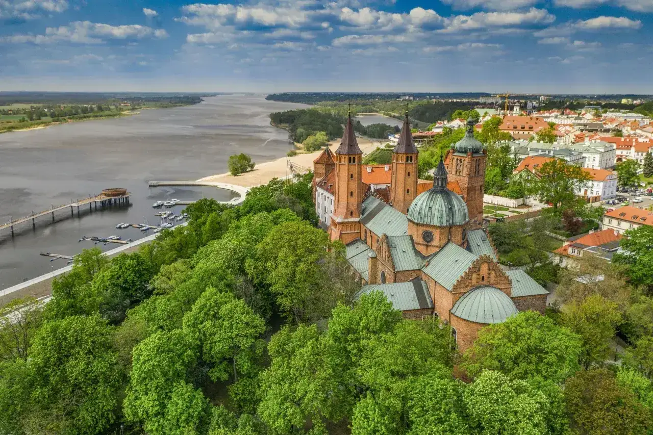 Płock atrakcje na weekend: majestatyczna katedra na wzgórzu, Wisła i zielone drzewa tworzą malowniczy krajobraz.