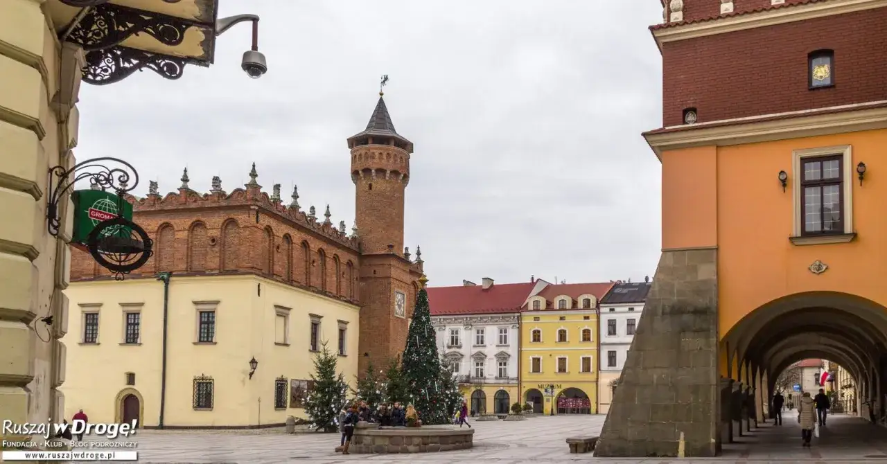 Tarnów atrakcje na weekend: Rynek z ratuszem, wieżą i kolorowymi kamieniczkami, ozdobiony świąteczną choinką.
