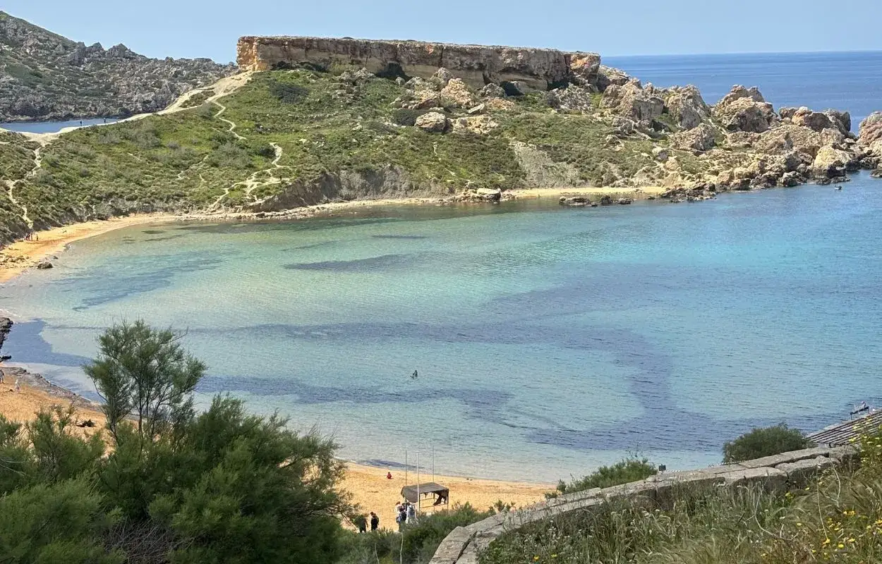Piękna zatoka na Malcie, z turkusową wodą i piaszczystą plażą. Czy na Malcie jest drogo? Widok sugeruje, że warto zainwestować w podróż!