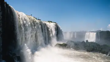 Potężne wodospady Iguazú w Argentynie, kaskady wody spadające z klifów, otoczone zielenią i spowite mgiełką.
